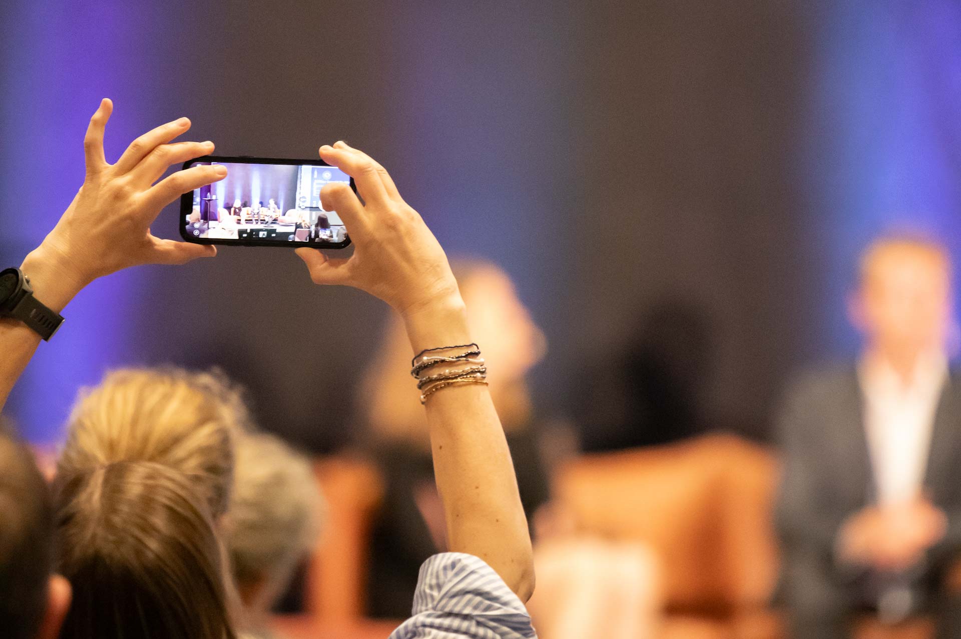 Konferensdeltagre tar bild med en mobiltelefon